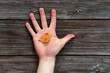 Small autumn leaf in young man hand on a wooden background. Photo was taken 26 September 2023 year, msk time.