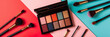 Colorful eyeshadow palette and professional makeup brushes on a multicolored background. Beauty and makeup concept with copy space for cosmetics design and tutorials.