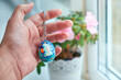 Keychains in the form of Ukrainian Easter egg with Petrykivka painting in the palm. Hand-painted wooden decor.