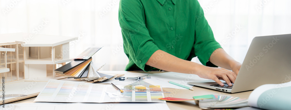 Cropped image of professional interior designer using laptop to create ...