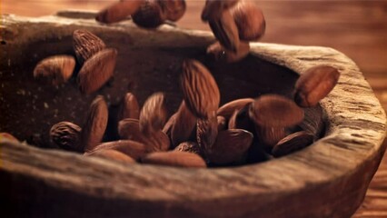 Canvas Print - Almond drops wooden bowl. Filmed on a high-speed camera at 1000 fps. High quality FullHD footage