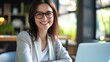 © Generative AI - Happy Brunette Business Lady Using Laptop Smiling To Camera Posing Wearing Glasses Working Sitting At Workplace In Modern Office. Successful Entrepreneurship And Career Concept : Generative AI