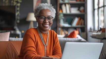 Wall Mural - black woman using laptop in home office. Remote work from home concept with cheerful adult