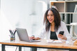 © PRIME STOCK LAB - Smiling African American Businesswoman Using Smartphone at Work.