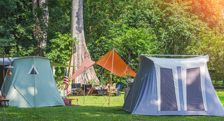Wall Mural - two field tents with outdoor camping equipment on campground area at natural parkland