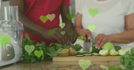 Sticker - Image of hearts over senior african american couple cooking