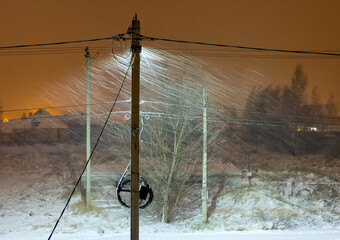 Canvas Print - It's snowing at night in the light of a lantern on a pole