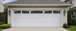 A typical garage door background. A typical American white garage door with a driveway in front. 