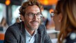© TheGoldTiger - A smiling man with glasses engaged in a conversation with a woman at a well-lit venue., generative ai