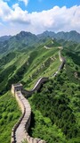 Fototapeta Góry - The Great Wall of China snakes through lush green hills under a bright blue sky., generative ai