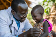 © Nataliia_Trushchenko - happy african male doctor examining baby girl. African male pediatrician hold stethoscope exam child boy patient visit doctor , black paediatrician check heart lungs of kid do pediatric checkup