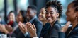 © Simon - A smiling business woman applauds at a business conference.