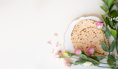 Wall Mural - Passover. Holiday of Jewish people. Traditional Matzo prepared for Passover decorate by flowers on white background. banner. top view. Spring Holiday. Fasting time