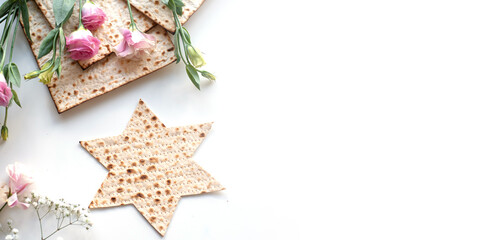 Wall Mural - Passover. banner of Traditional Matzo shape of star Magen David  decorate by pink flowers on white background. top view. Holiday of Jewish people, Spring Holiday. Fasting time