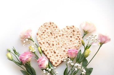 Wall Mural - Passover. banner of Traditional Matzo shape of heart  decorate by pink flowers on white background. top view. Holiday of Jewish people, Spring Holiday. Fasting time