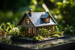 Miniature model of a house with a solar panel on the roof