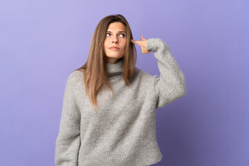 Young Slovak woman isolated on purple background making the gesture of madness putting finger on the head