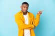 © luismolinero - Young latin man isolated on blue background pointing finger to the side