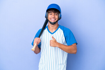 Wall Mural - Baseball caucasian man player with helmet and bat isolated on blue background giving a thumbs up gesture