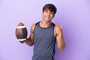 Wall Mural - Young man playing rugby isolated on purple background giving a thumbs up gesture