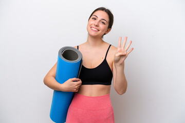 Young sport girl going to yoga classes while holding a mat isolated on white background happy and counting four with fingers