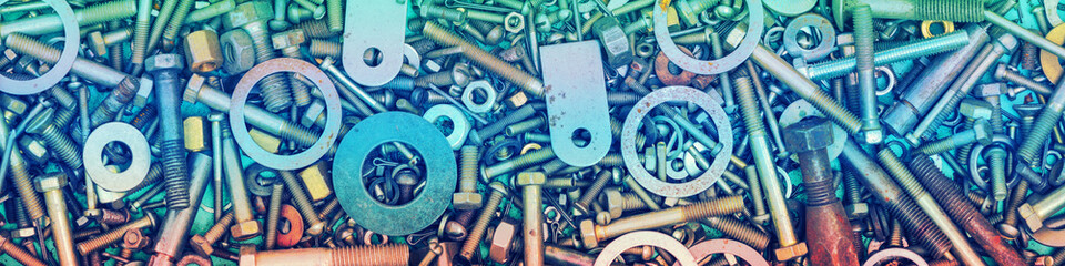 Abstract grunge colorful metal background made of fastening bolts, screws, and nuts. Horizontal banner