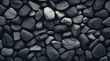 Textured pebble concrete featuring a predominantly black hue with scattered grey pebbles for accentuation.