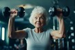 Elderly woman exercises with dumbbells at gym