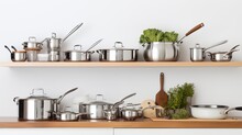 A Set Of Stainless Steel Kitchen Pots And Pans Neatly Arranged On A White Countertop