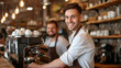 © Studio Nova - two smiling men in a cafe, one in the foreground wearing a white shirt and leather apron