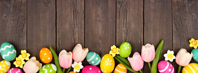 Aufkleber - Easter eggs and flower decorations. Top view bottom border against a dark rustic wood banner background. Copy space.
