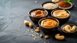 Bowls with tasty peanut butter on dark background, closeup