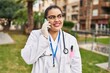 © Krakenimages.com - Young beautiful plus size woman doctor smiling confident talking on smartphone at park