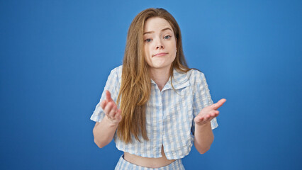 Young blonde woman standing clueless over isolated blue background