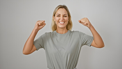 Sticker - Portrait of a young, cheerful, caucasian woman flexing her muscles confidently against a white background.