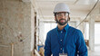 Young hispanic man architect standing with serious face at construction site