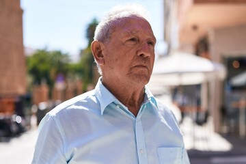 Poster - Middle age grey-haired man looking to the side with serious expression at coffee shop terrace