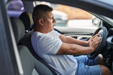 Wall Mural - Young latin man stressed driving car at street