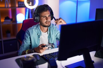 Sticker - Young hispanic man streamer playing video game using joystick at gaming room