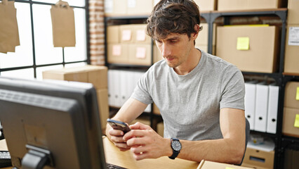 Sticker - Young hispanic man ecommerce business worker using smartphone at office