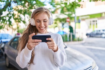 Wall Mural - Young blonde woman smiling confident watching video on smartphone at street