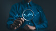 © Supatman - Stock trading and investing concept. Businessman or trader hand holding magnifying glass with virtual stock graph market chart. foreign exchange, trade fund, crypto money, Business growth, investor,