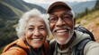 Close-up selfie of a smiling elderly interracial couple outdoors with lush greenery in the background, showcasing joy and companionship.