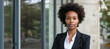 © Nataliia_Trushchenko - Beauty portrait of african american woman with afro hairstyle. Excited african woman with wide smile looking aside. Confident African American Businesswoman Against office Background.