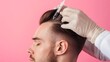 Young man with hair loss problem receiving injection on color background, closeup 