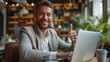 © akarawit - Businessman using laptop with thumbs up in the office