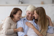 © fizkes - Cheerful adult woman hugging older senior parents, smiling, laughing, chatting with mom and dad, having fun, enjoying relationship, affection, care. Family celebrating fathers day