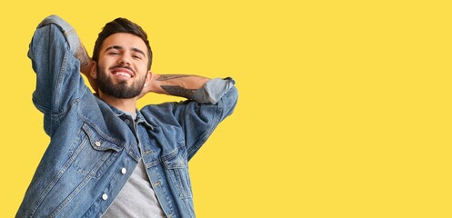 Wall Mural - Handsome bearded young man in jeans clothes on yellow background with space for text