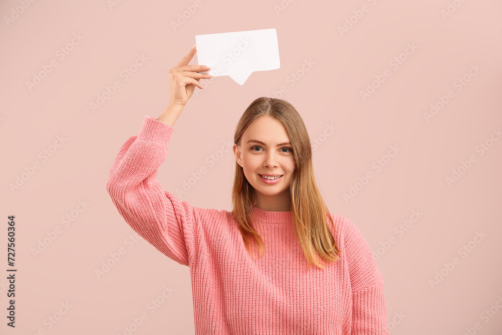 Pretty young woman holding blank speech bubble on pink background