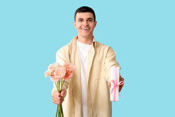 Poster - Handsome man with gift box and flowers on blue background